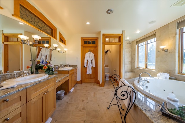 bathroom featuring a whirlpool tub, vanity, toilet, and recessed lighting