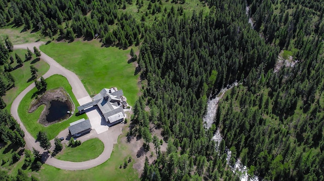 birds eye view of property featuring a view of trees