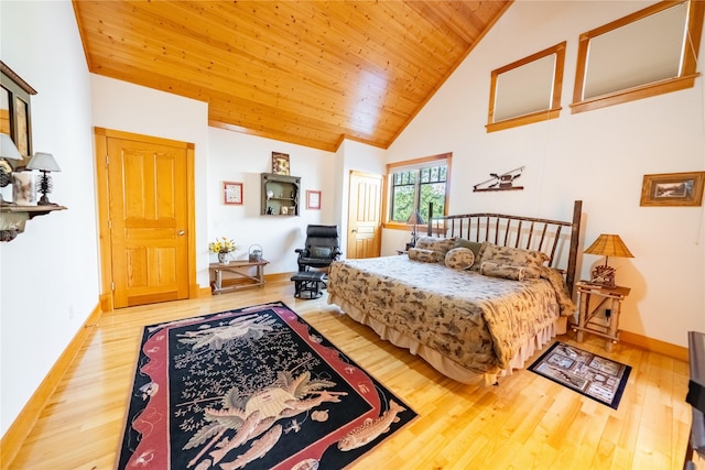 bedroom with high vaulted ceiling, wood ceiling, baseboards, and wood finished floors