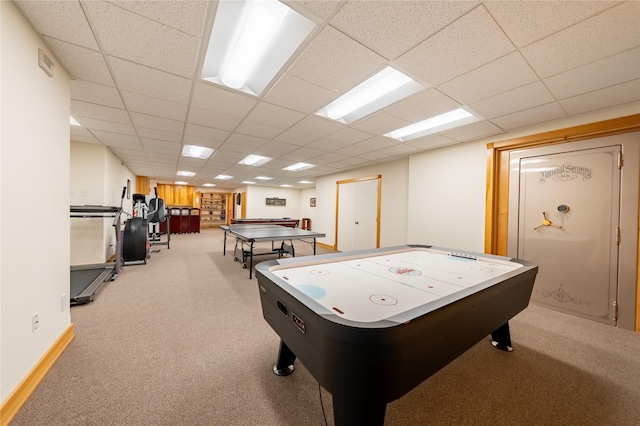 game room featuring a paneled ceiling, light carpet, and baseboards