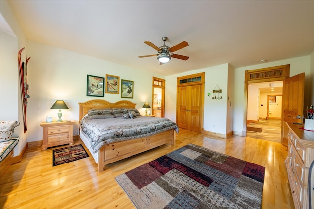 bedroom with light wood-type flooring, ceiling fan, and baseboards