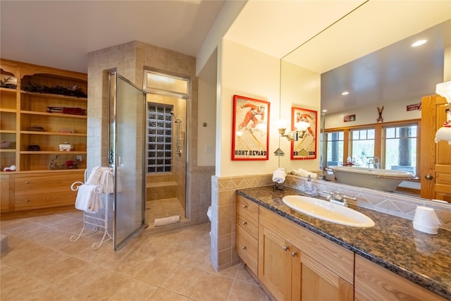 bathroom with tile patterned flooring, a wainscoted wall, vanity, tile walls, and a shower stall