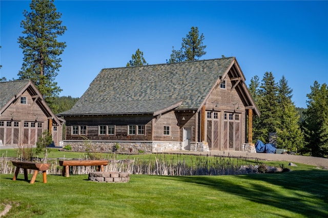 back of house with a barn, a lawn, and an outdoor structure