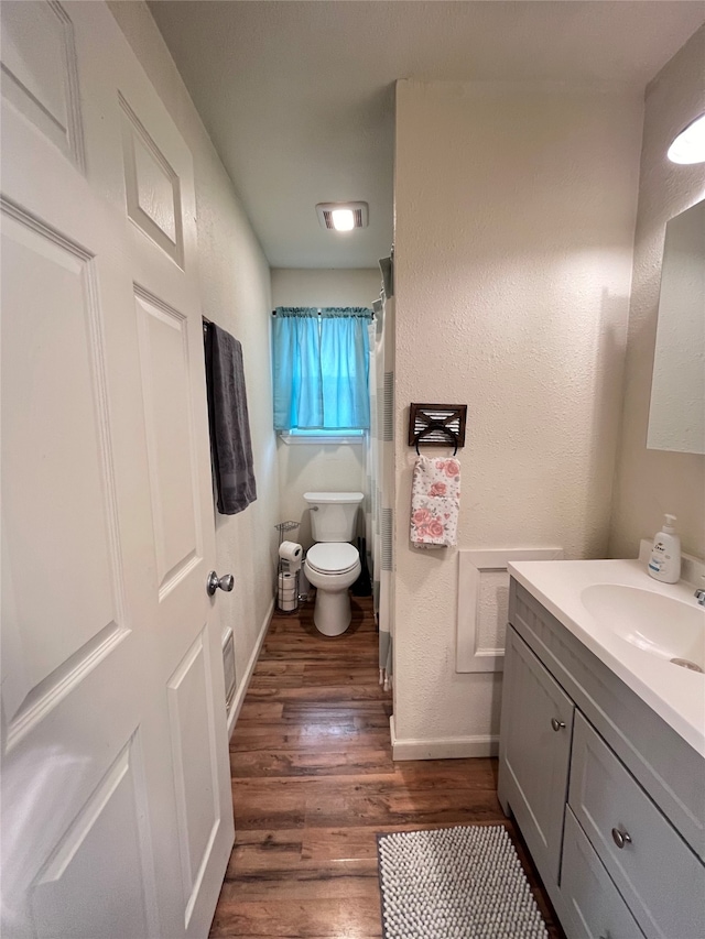 bathroom featuring hardwood / wood-style floors, vanity, and toilet