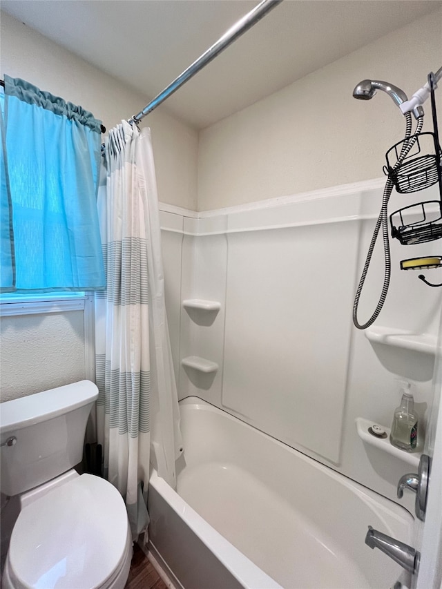 bathroom with shower / bath combination with curtain and toilet