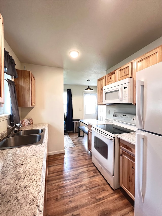 kitchen with pendant lighting, white appliances, dark hardwood / wood-style floors, light brown cabinetry, and sink