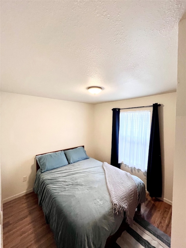 bedroom featuring hardwood / wood-style flooring and a textured ceiling