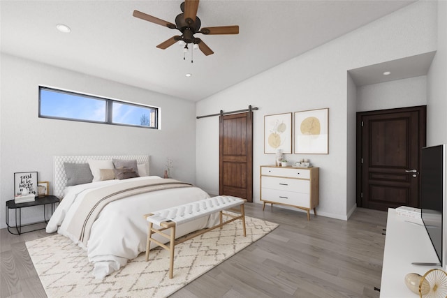 209 Mannington St, Kalispell, MT 59901 - bedroom with a barn door, light wood-style flooring, vaulted ceiling, recessed lighting, and a ceiling fan