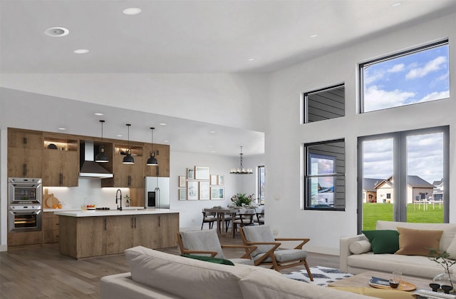 209 Mannington St, Kalispell, MT 59901 - living area featuring light wood-style flooring, healthy amount of natural light, recessed lighting, a chandelier, and a high ceiling
