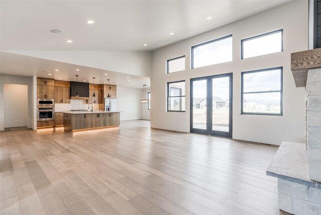 209 Mannington St, Kalispell, MT 59901 - unfurnished living room featuring high vaulted ceiling, plenty of natural light, light wood finished floors, and recessed lighting