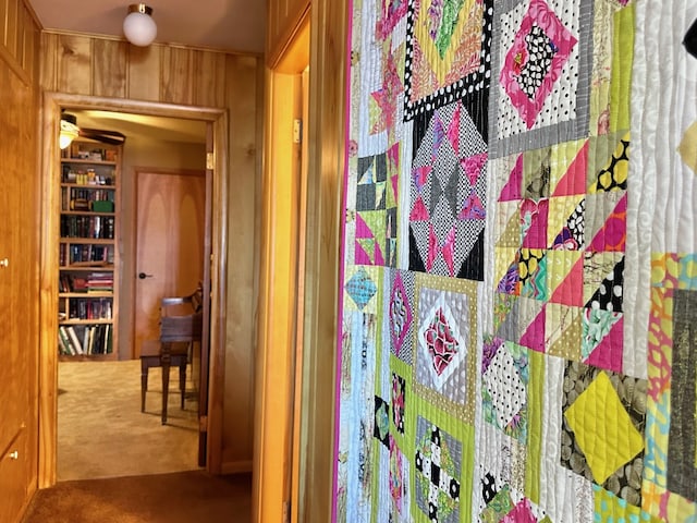 interior space with carpet flooring and wooden walls