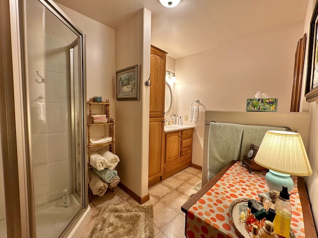 bathroom with a shower with door, vanity, and tile patterned flooring