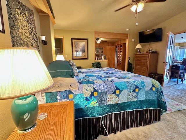 carpeted bedroom featuring multiple windows, wooden walls, and ceiling fan