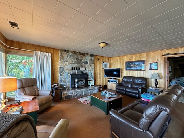 carpeted living room with wood walls and a fireplace