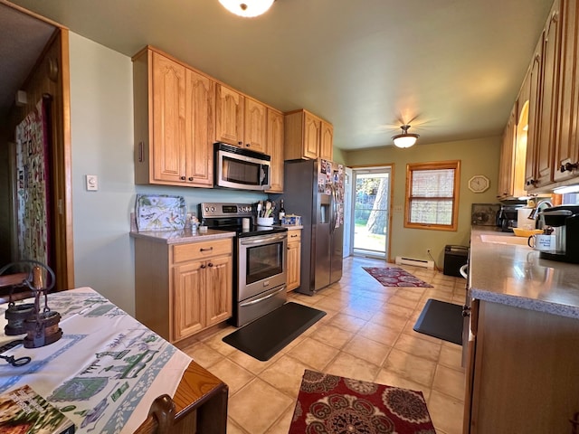 kitchen with light brown cabinets, light tile patterned floors, stainless steel appliances, and a baseboard heating unit