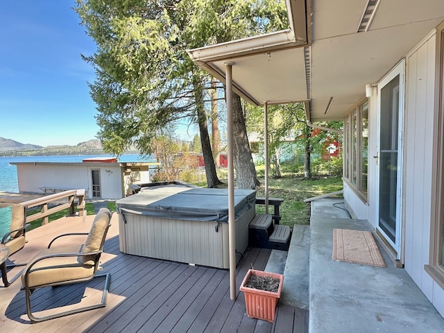 deck featuring a water and mountain view and a hot tub