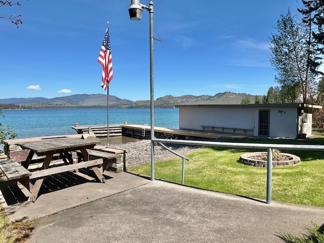 exterior space with a fire pit and a water and mountain view