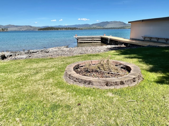 exterior space with a yard and a water and mountain view