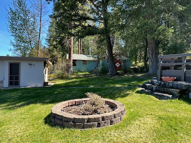 view of yard featuring a fire pit and a storage unit