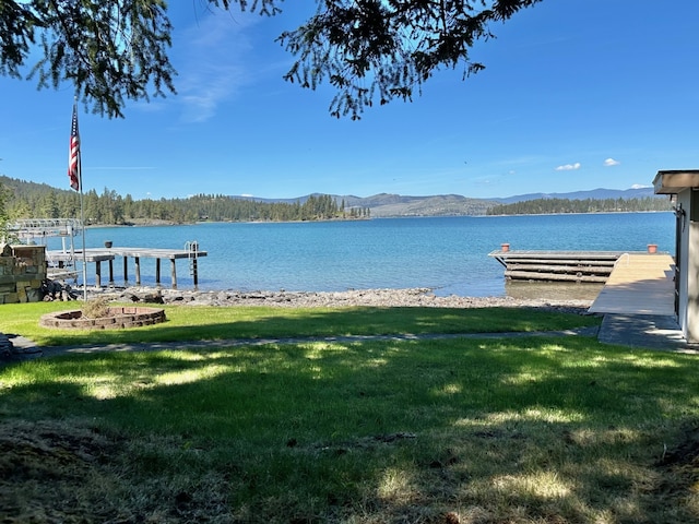 view of dock featuring a yard and a water and mountain view