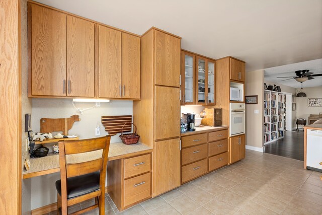 kitchen featuring vaulted ceiling, light tile flooring, ceiling fan, a kitchen bar, and white refrigerator with ice dispenser