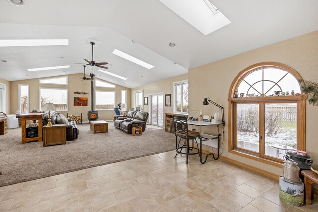 living room with a wealth of natural light, carpet, ceiling fan, and a skylight