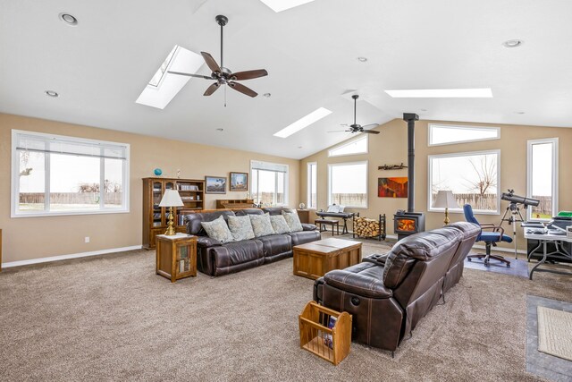 carpeted living room featuring ceiling fan and lofted ceiling with skylight