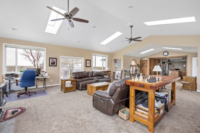 living room featuring ceiling fan, vaulted ceiling with skylight, and light carpet