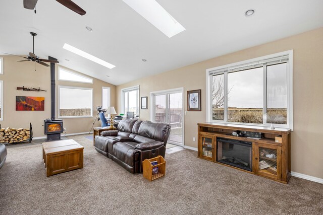 tiled entryway with ceiling fan and lofted ceiling with skylight