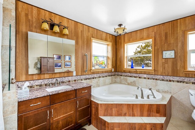 bathroom with a tile shower, dual bowl vanity, tasteful backsplash, and tile walls