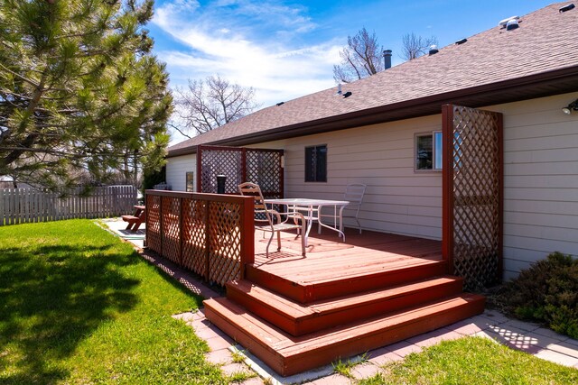 rear view of house with a lawn and a wooden deck