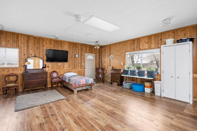 unfurnished living room featuring ceiling fan, a wood stove, and hardwood / wood-style floors