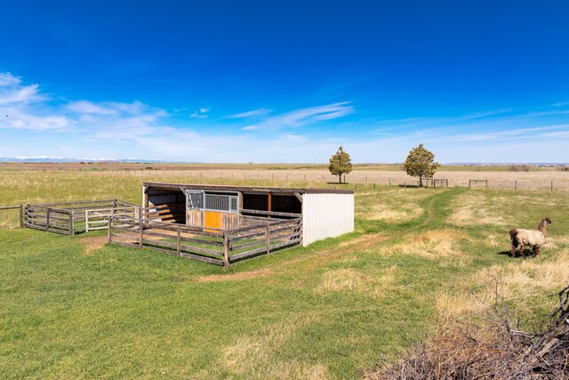 view of horse barn with an outdoor structure, a rural view, and a yard