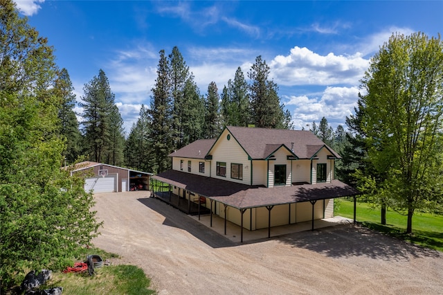 view of front of house featuring an outdoor structure, a carport, and a garage