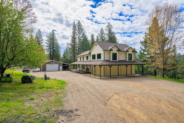 country-style home with an outdoor structure, a carport, and a garage