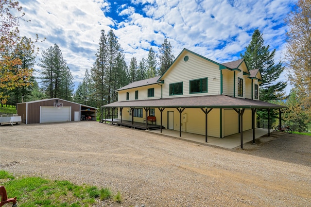 farmhouse inspired home featuring an outdoor structure, a garage, and a carport