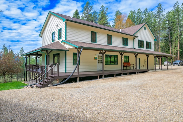 farmhouse inspired home featuring covered porch and a carport