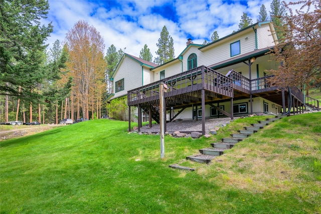 rear view of property featuring a lawn and a wooden deck