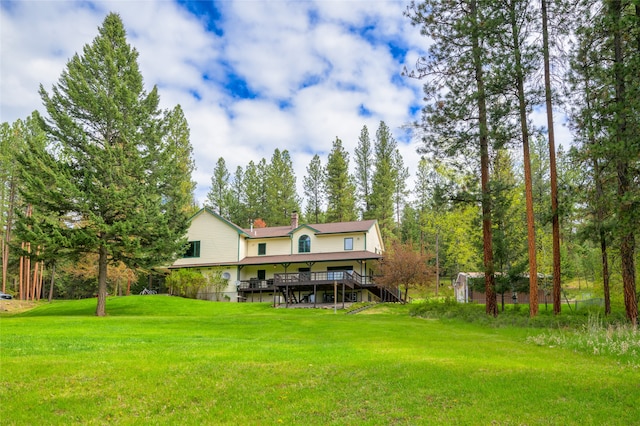 rear view of house with a yard and a deck