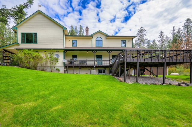 rear view of house with a yard, central air condition unit, and a wooden deck