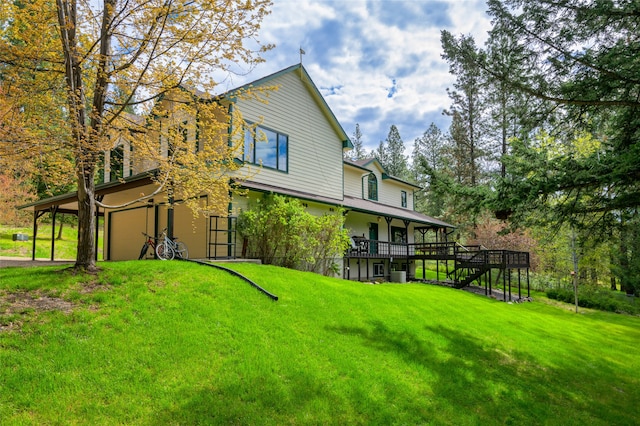 rear view of house with a wooden deck and a yard