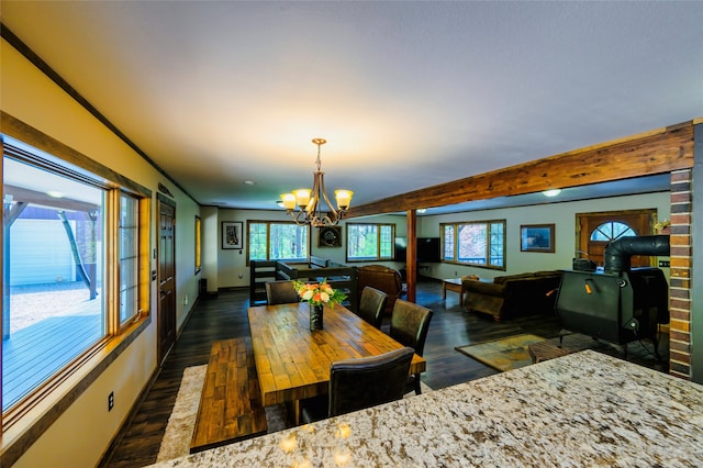 dining space featuring dark hardwood / wood-style floors, beamed ceiling, and a notable chandelier