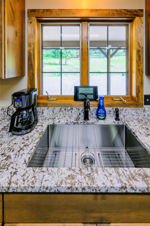 kitchen with sink, plenty of natural light, and light stone counters