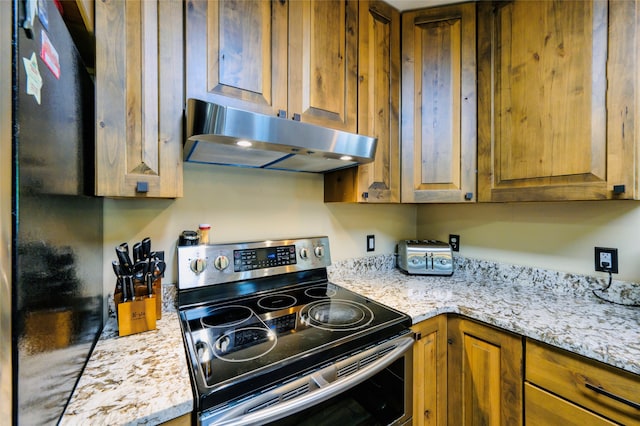 kitchen featuring light stone counters and electric stove