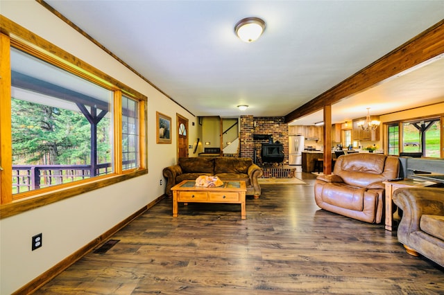 living room with brick wall, an inviting chandelier, beamed ceiling, dark hardwood / wood-style flooring, and a wood stove