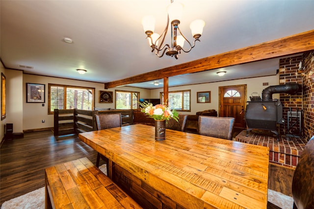 dining room featuring brick wall, a wood stove, a notable chandelier, hardwood / wood-style flooring, and beam ceiling