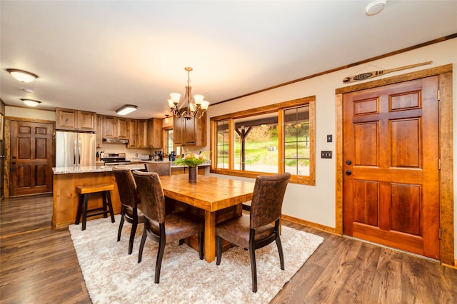 dining space featuring crown molding, an inviting chandelier, and hardwood / wood-style floors