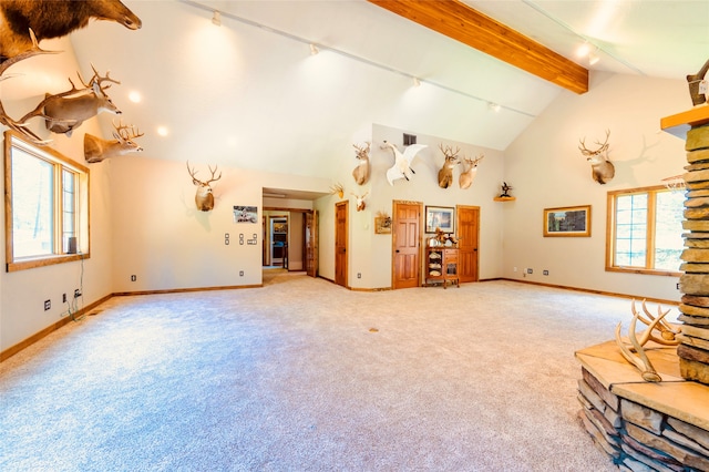 unfurnished living room with carpet flooring, beamed ceiling, high vaulted ceiling, and rail lighting