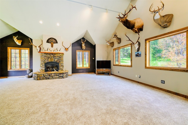 unfurnished living room featuring carpet flooring, a fireplace, plenty of natural light, and rail lighting