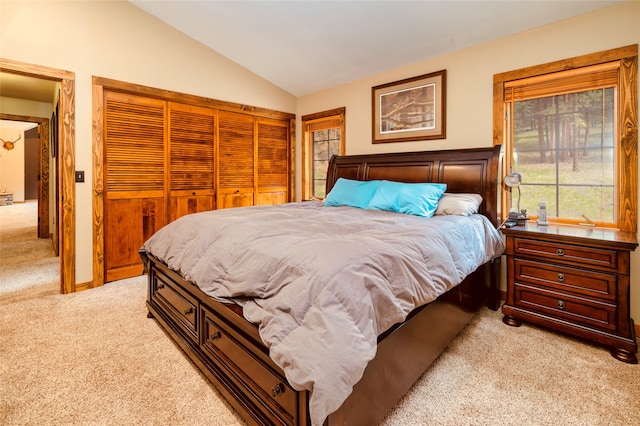 carpeted bedroom featuring vaulted ceiling and a closet